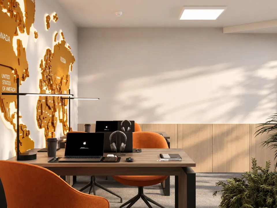 Desks with laptops and orange chairs