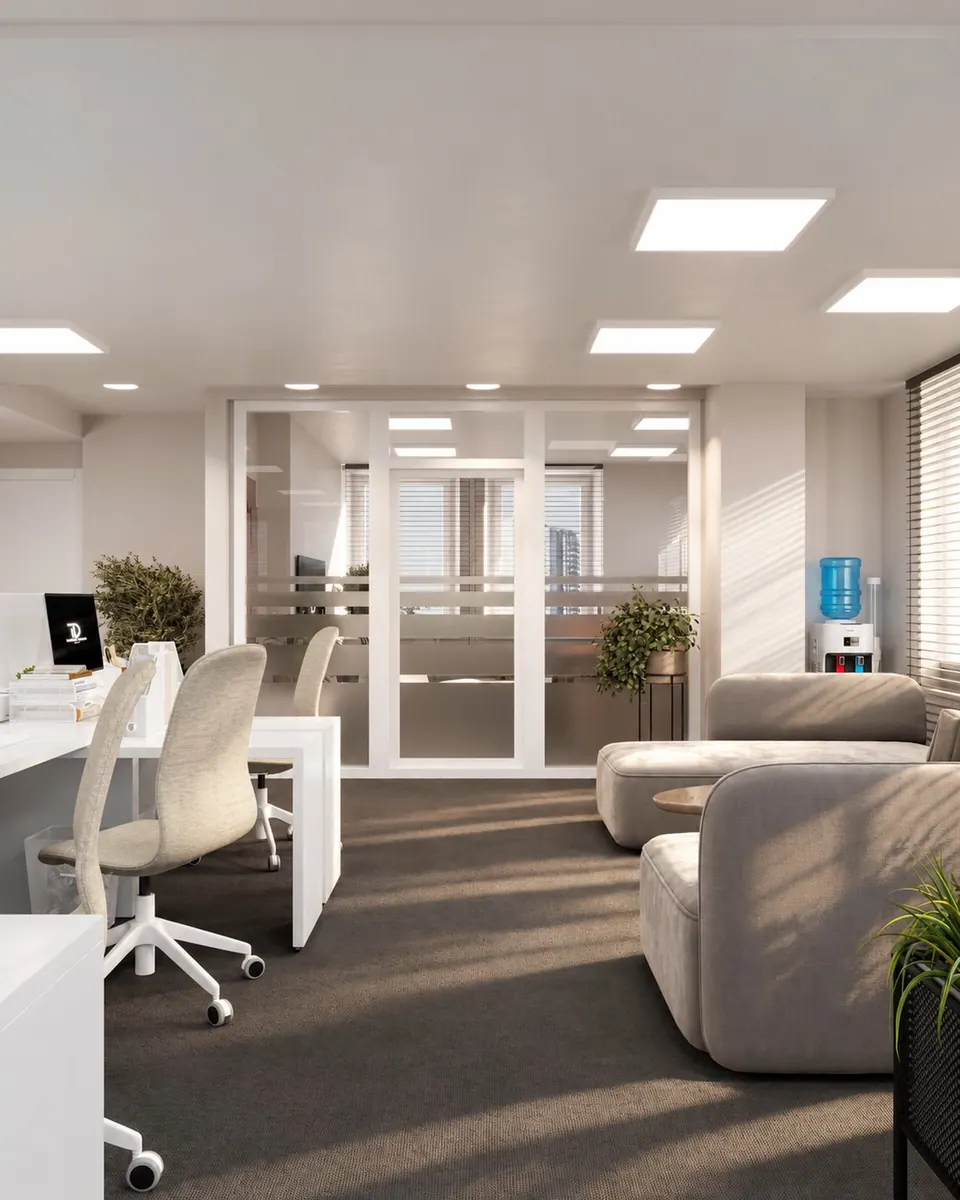Open-plan workspace with white desks and a lounge area